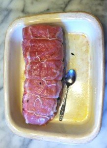 Tying the roast in baking dish.